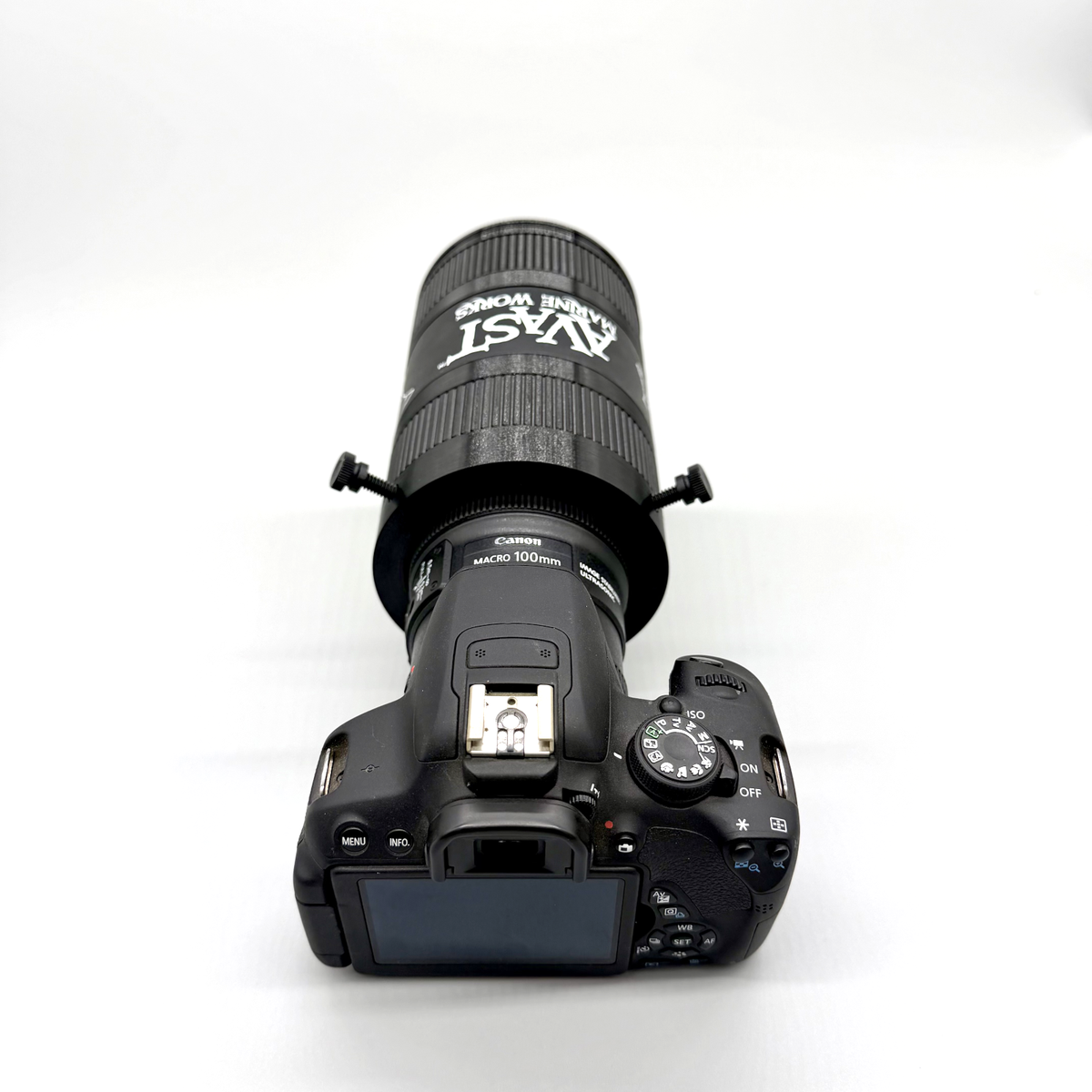 Camera with lens attached on a white background. Avast Marine Porthole Studio for DSLR. 3D-printed underwater coral and fish photography gear. Black camera lens with accessories on a white background.