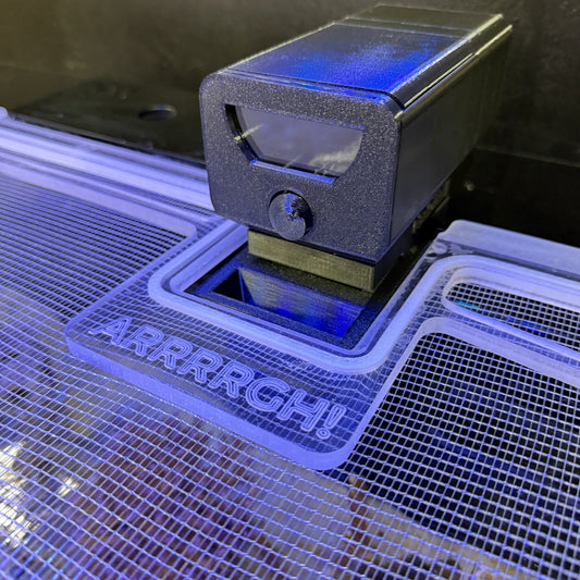 3D printer in action with a printed object displaying 'ARRRRGH!' text. Plank Cutout to MINI Conversion Plate