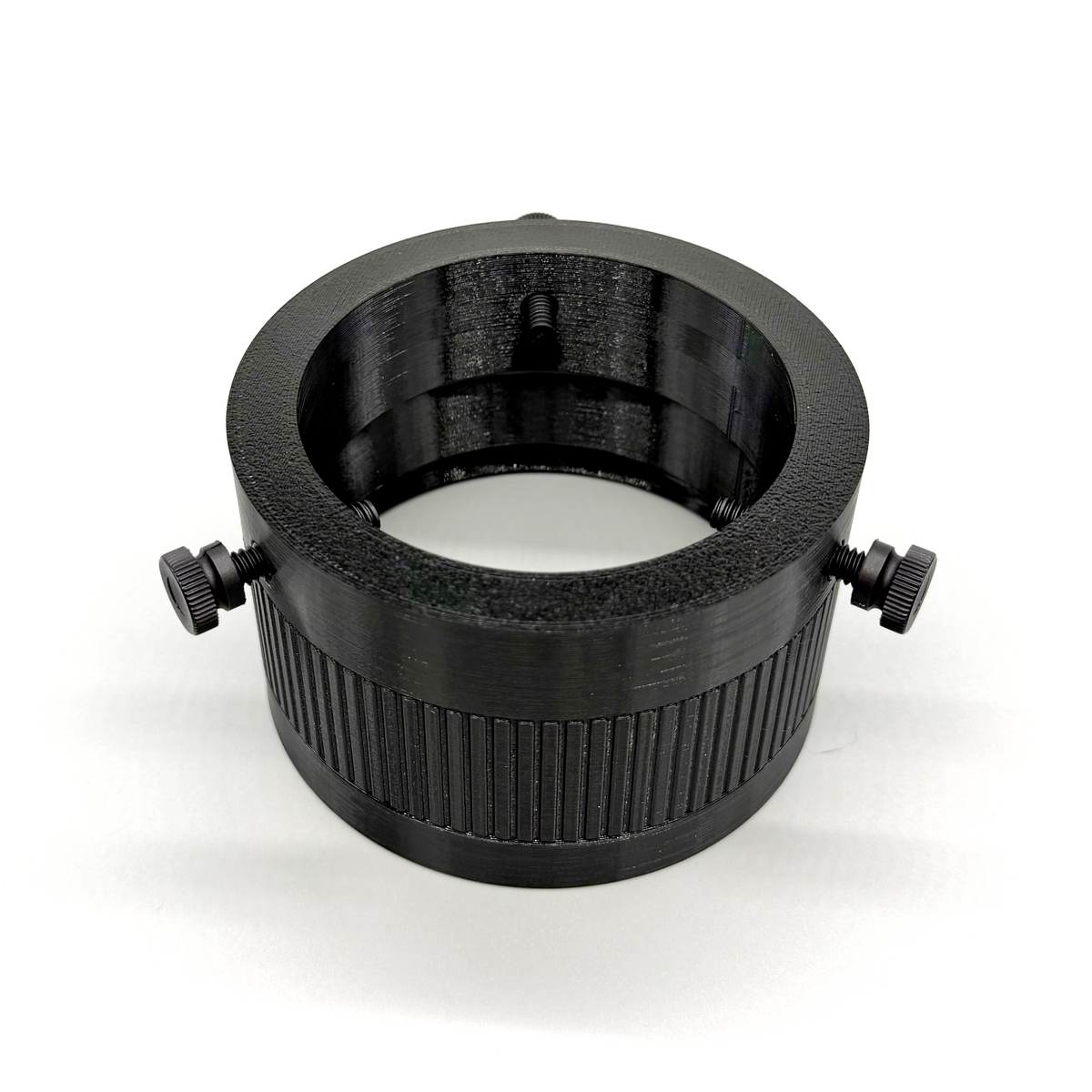 Black cylindrical lens or filter with threaded sides on a white background. Porthole Mark II Studio Upper Assembly